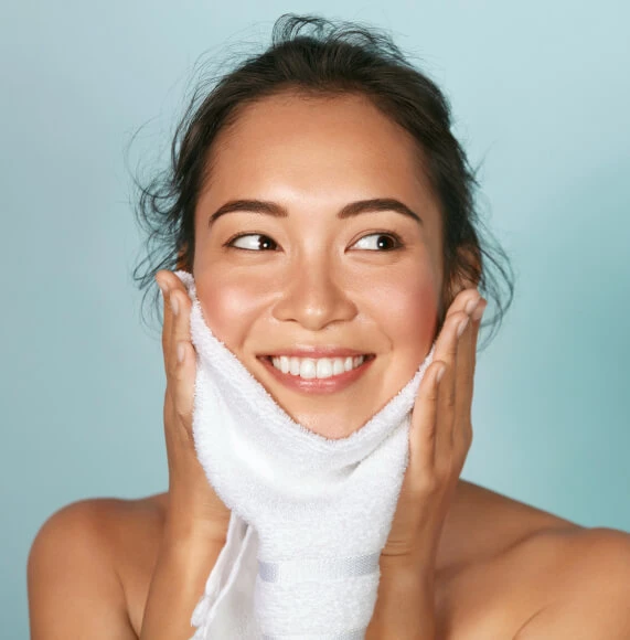 woman-in-bun-wiping-face-blue-background